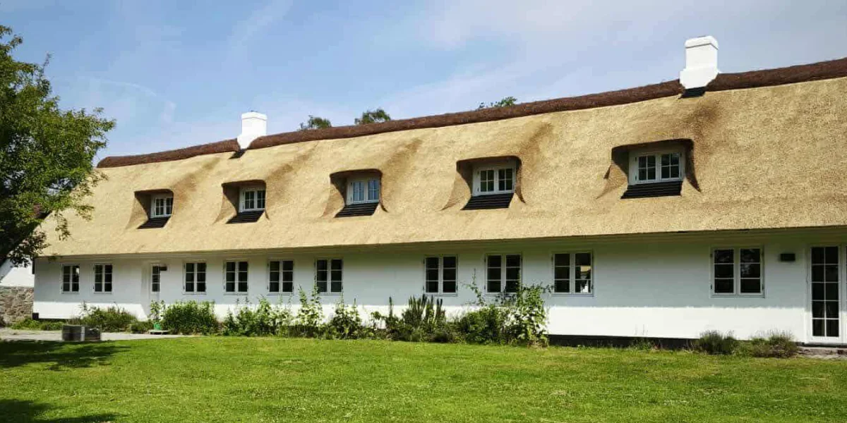 Long white cottage with thatched roof